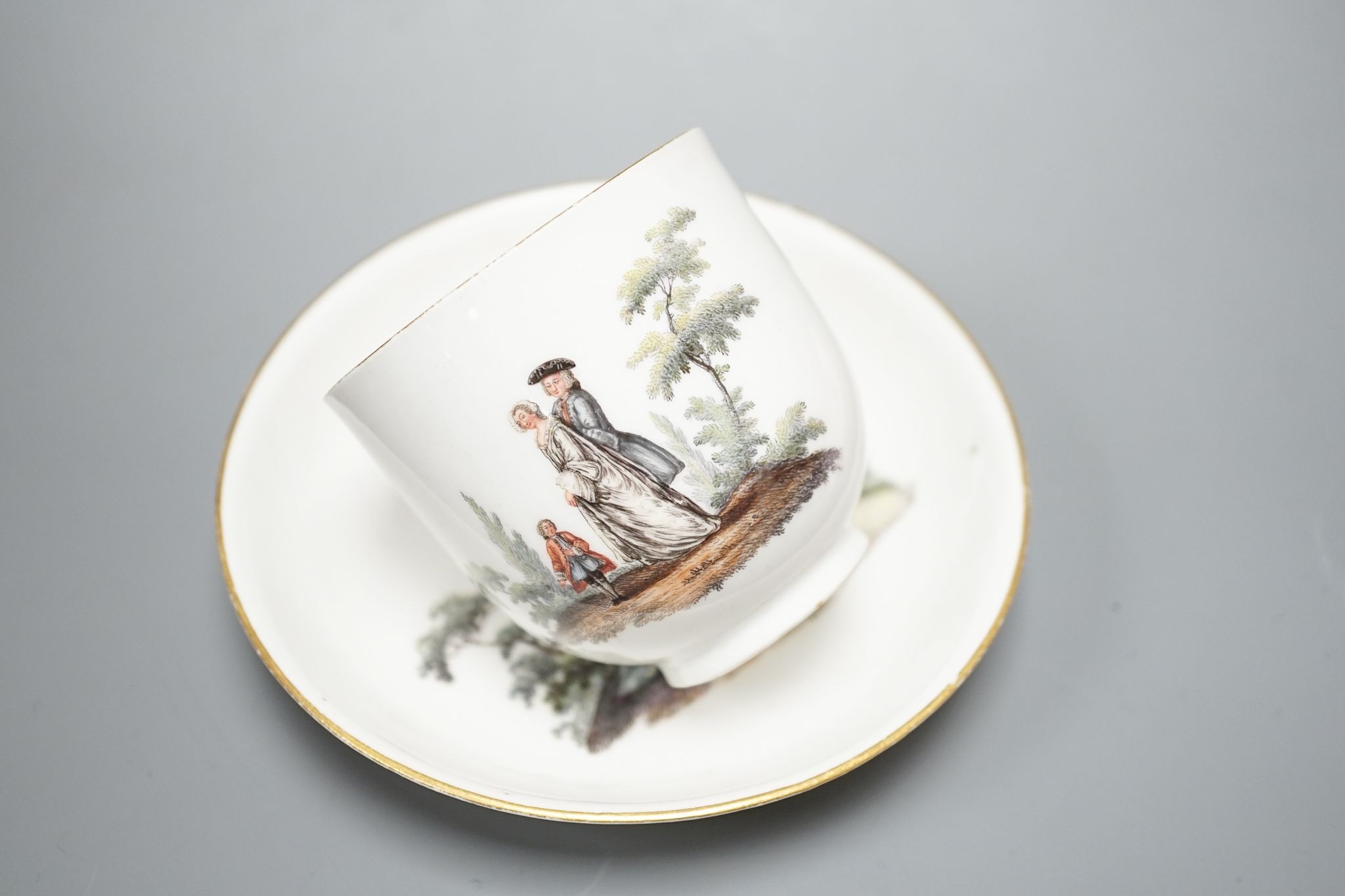 A 19th century Meissen porcelain tea cup and saucer decorated with 18th century figures